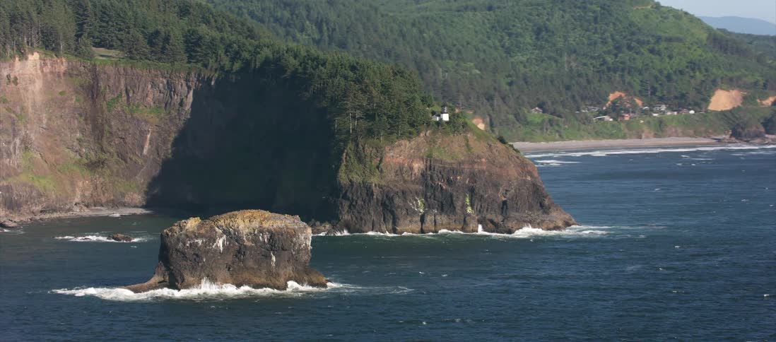 Houses sit on the cliff near the ocean