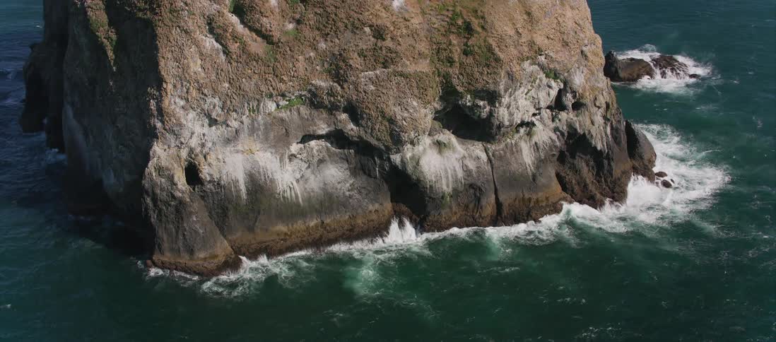 A rocky cliff island surrounded by ocean water