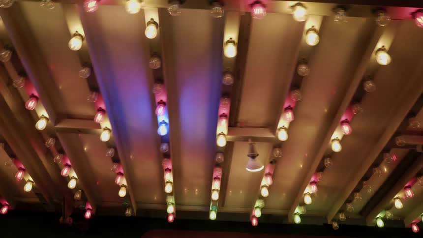 Multicolor lights flash under a roof above a business entrance