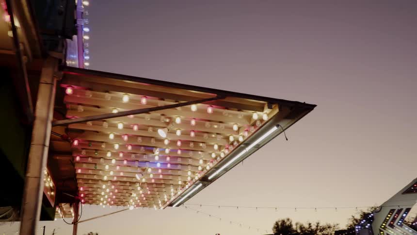 Multicolor lights shine above a carnival game
