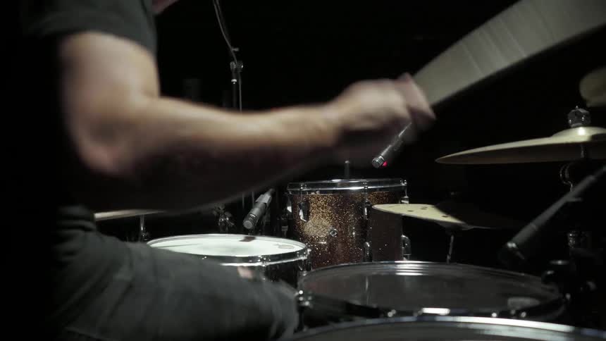 A man is playing drums on stage