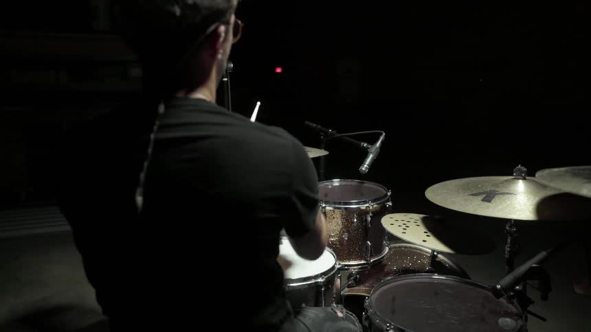 A man sitting down playing drums