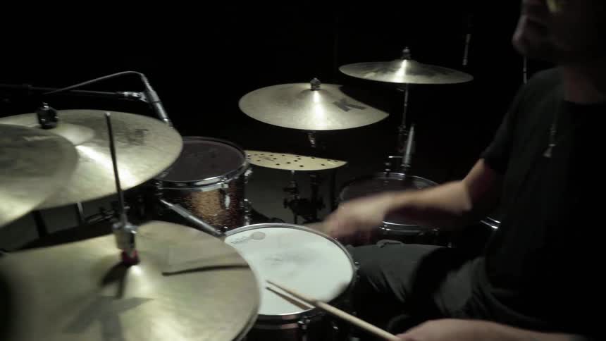 A man sitting playing drums