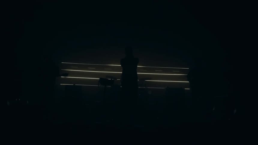 Vocalist performs with his group on the dark stage