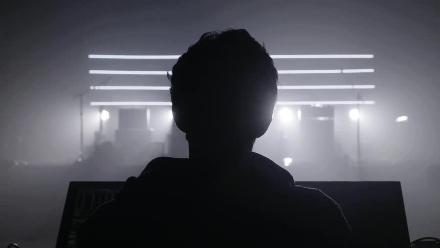 A man is standing at the controls near the stage