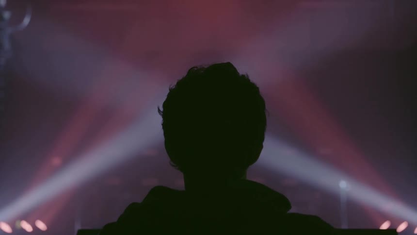 A man stands in front of strobe lights pointing upward in a row
