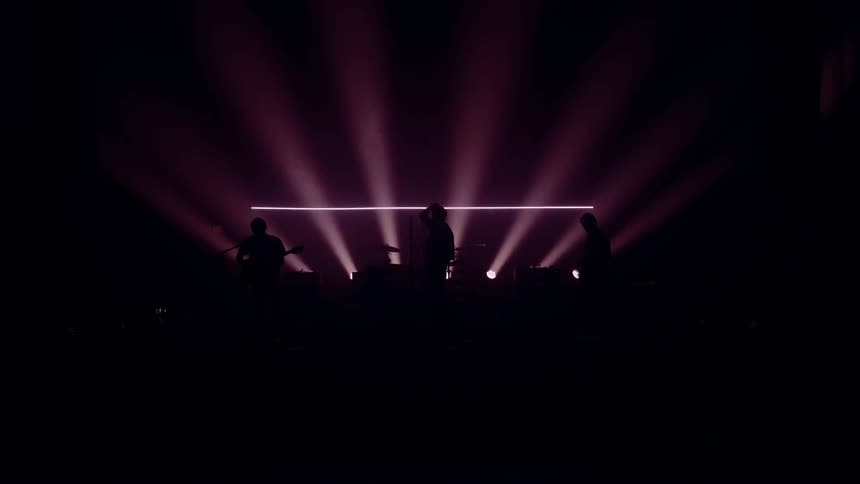 Band playing on dark backlit stage