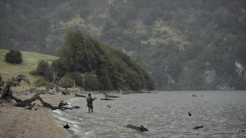 A man is fly fishing near the shore