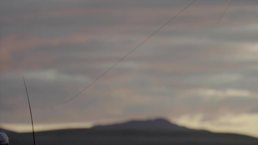 A person cast his fishing line at sunset