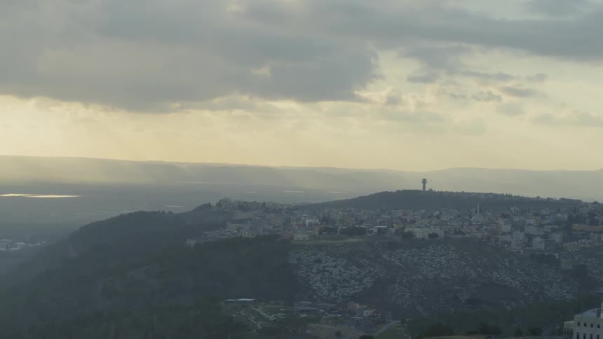 A town situated on a hill with a water tower behind it
