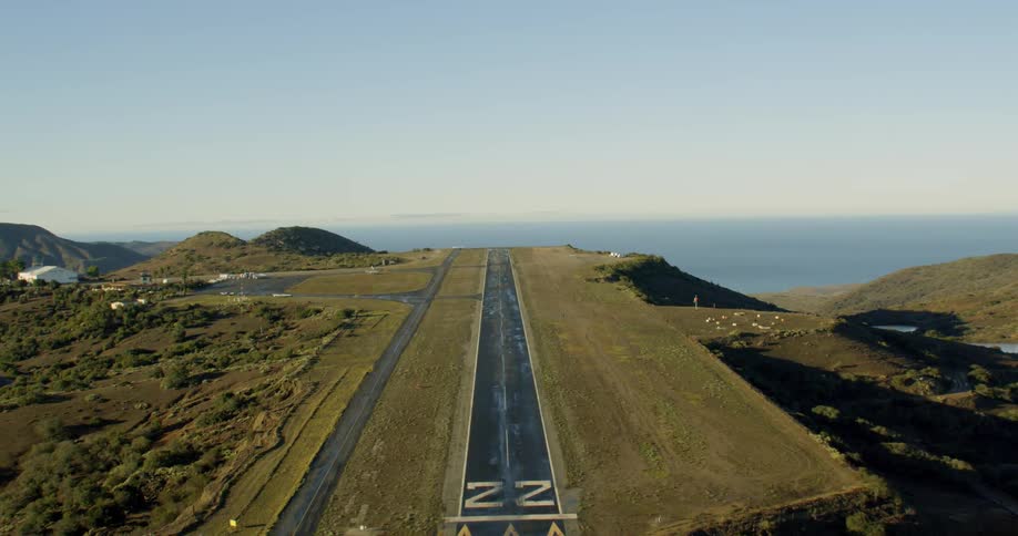 An isolated runway runs toward a cliff by the ocean
