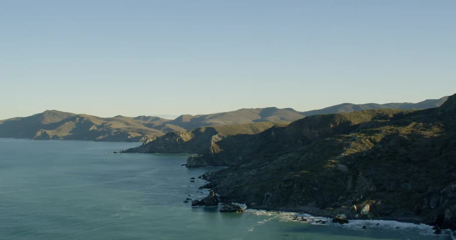 Camera flies along the hills at an ocean coast