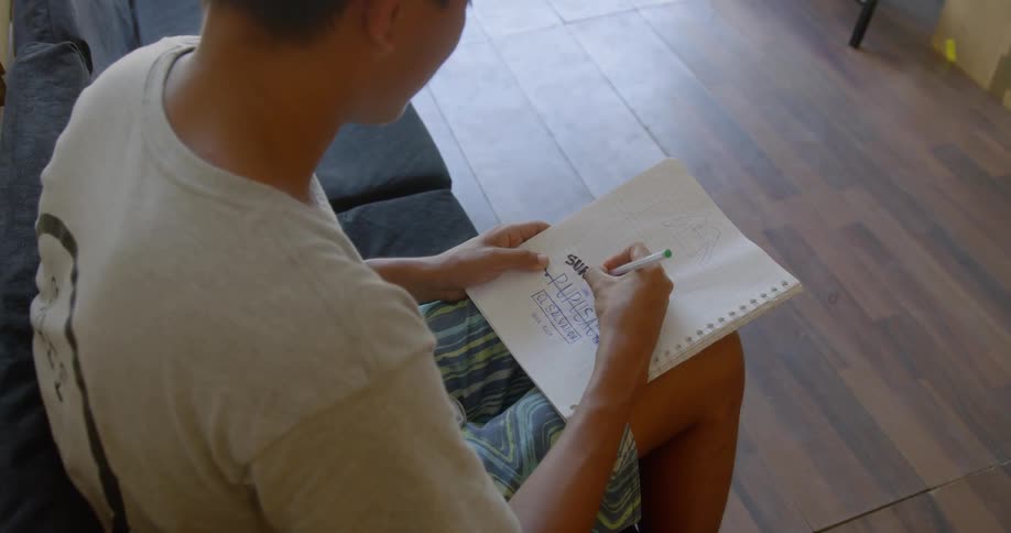 A man draws in a notebook