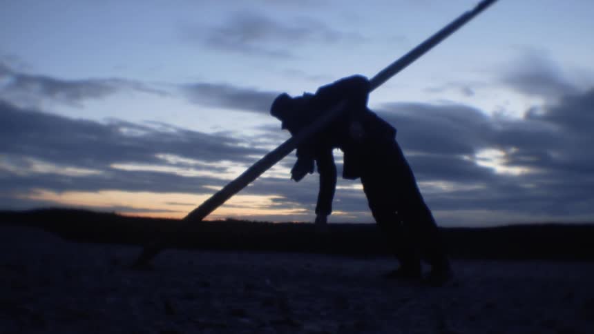 Man balancing on a leaning pole
