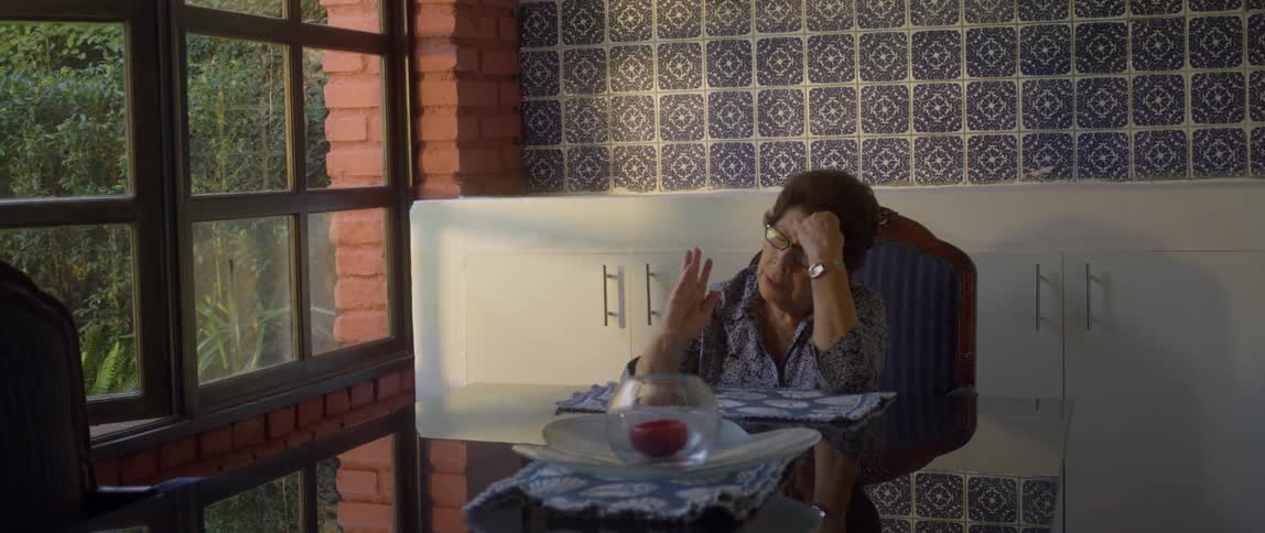 Woman sits at table praying