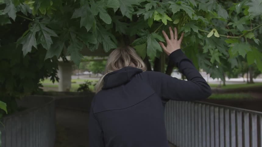 A white woman walks down a park path