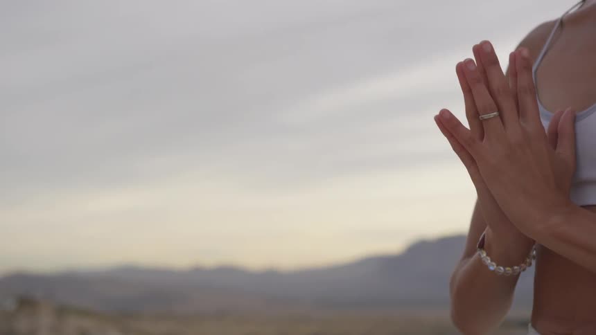 A white woman prays in the desert
