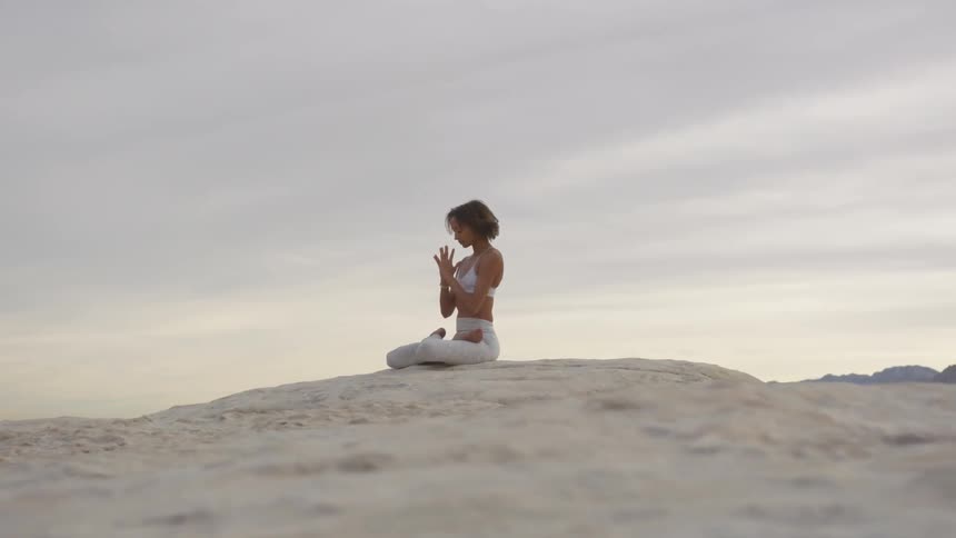 Woman meditating on the desert