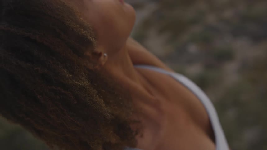 A woman looks off in the distance as she stretches her arm