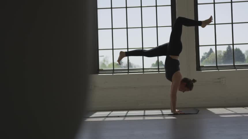 Woman practicing yoga over a mat at a studio