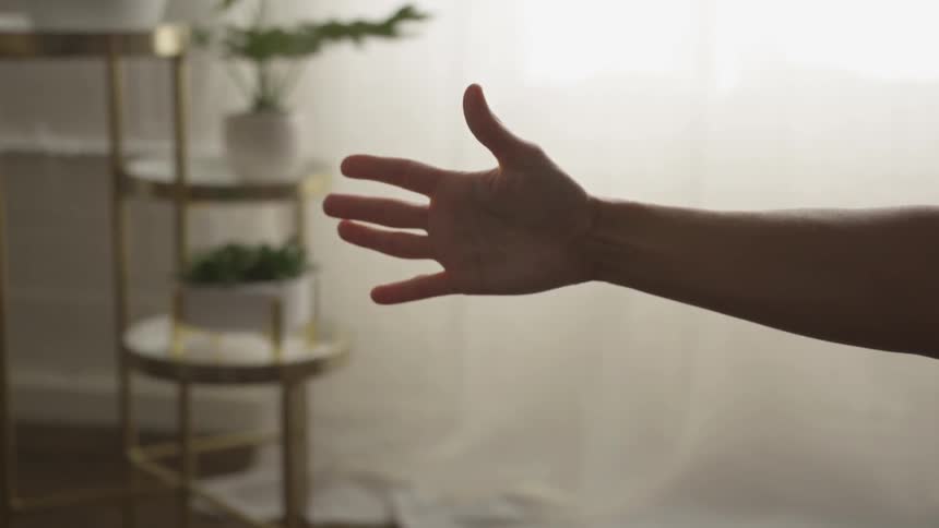 Woman stretched hand in front of a curtain