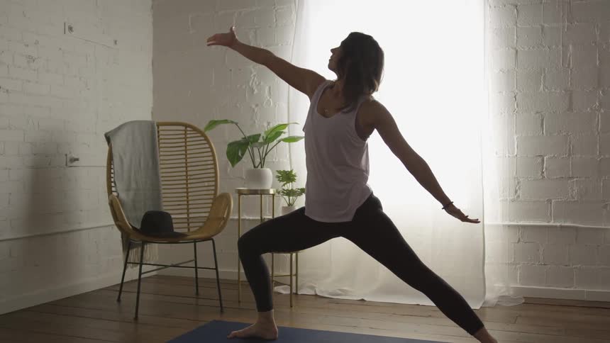 Woman practicing yoga over a mat indoors