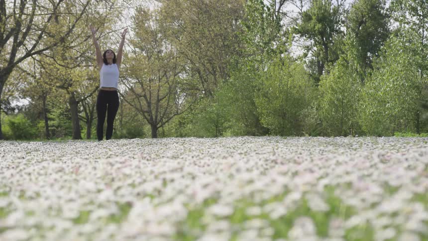 Woman practicing yoga in a field