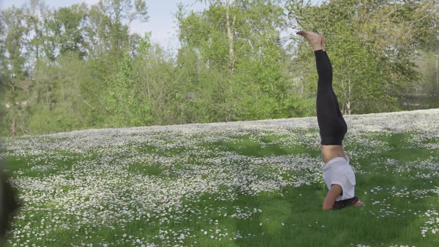 Woman practicing yoga on a field