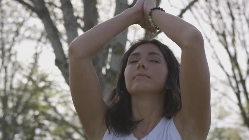 A woman does a yoga pose outside