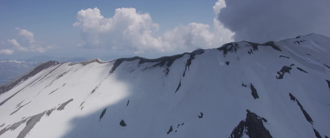 Landscape of the range of snow covered mountain with cloudy sky