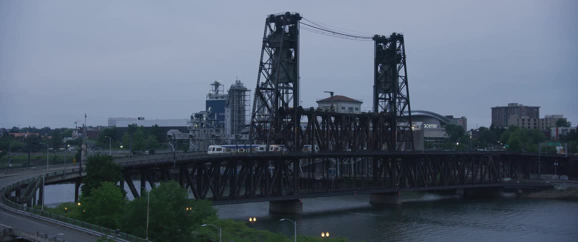A long cable car crosses a bridge