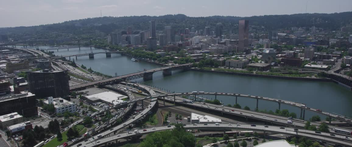 The camera flies over a city next to a river
