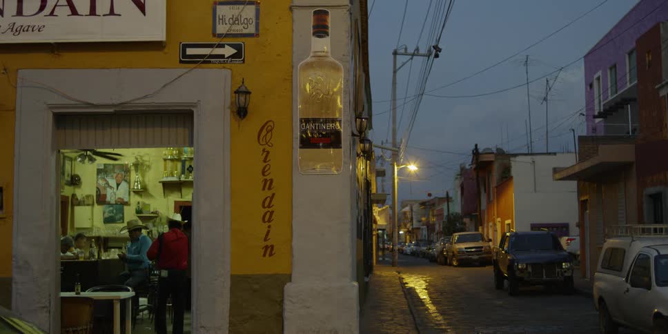 Cars are passing by small local bar on a city street