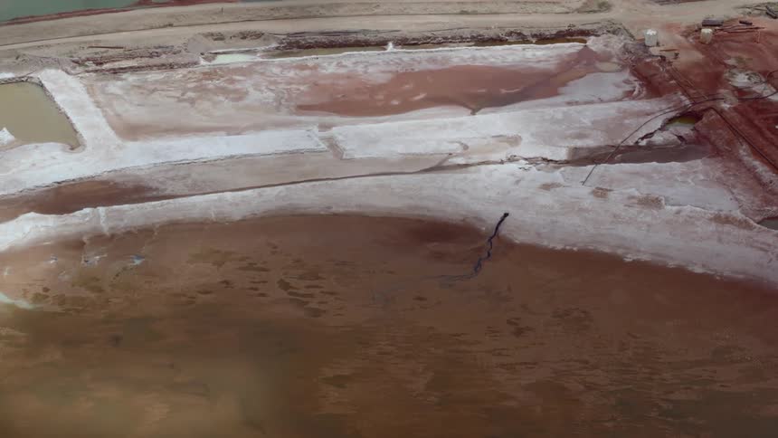 An aerial view of a chemical waste pool near a refinery