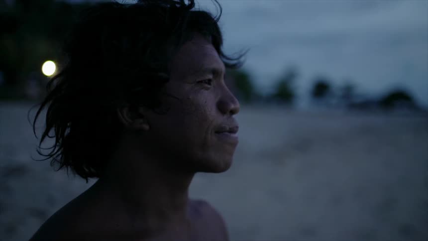 Man standing on the sand of a beach looking at the horizon