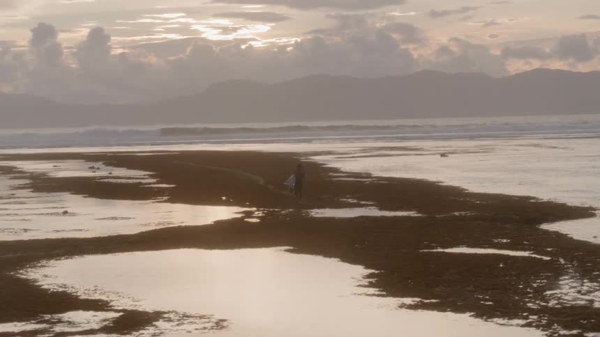 A man walks along the shoreline