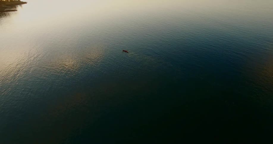 A kayak paddles across a large lake