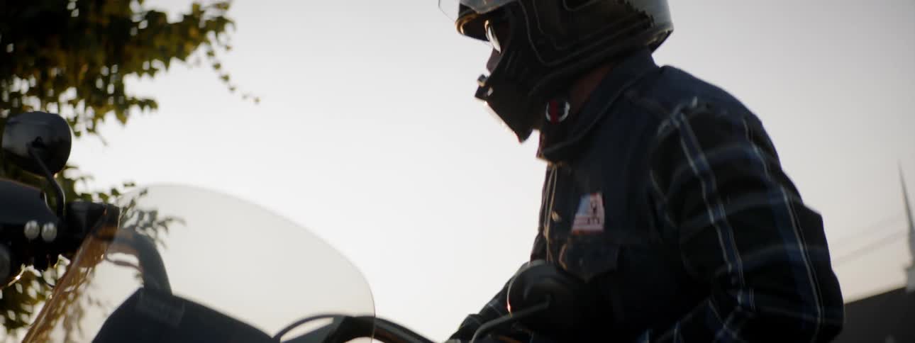 A man stands up from riding a motorcycle