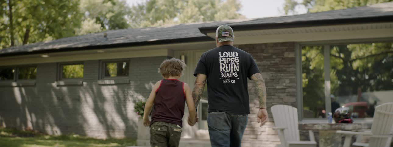 A man and child walk along holding hands
