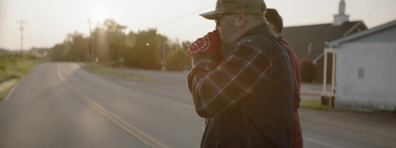 Two men walk across a street