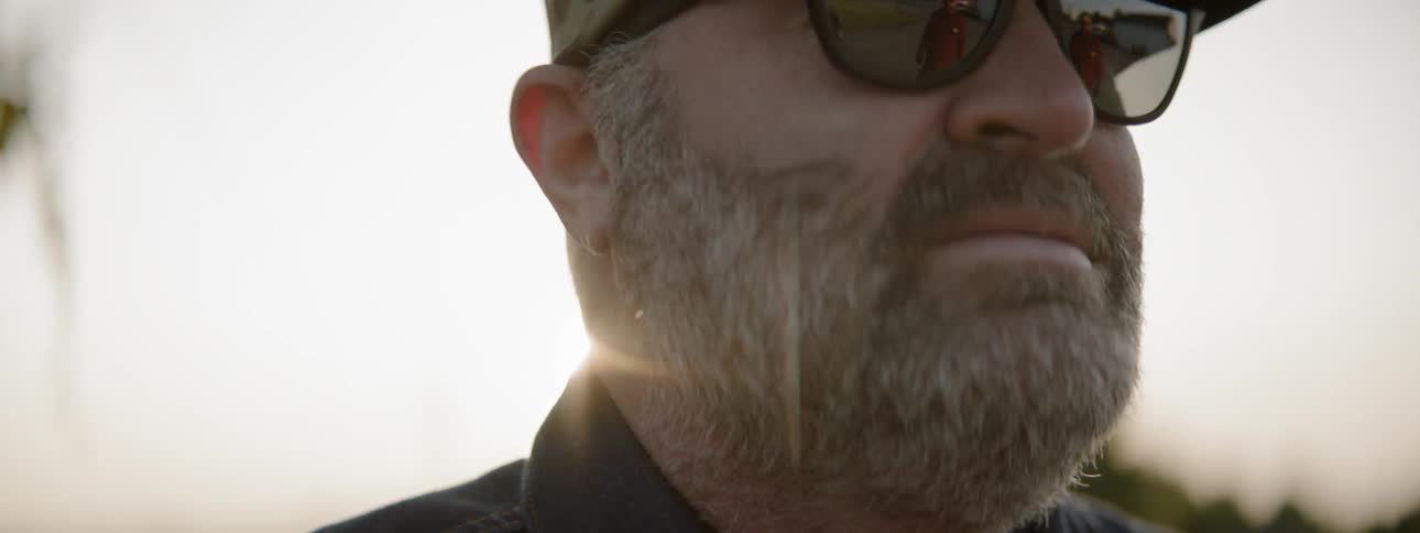 Bearded man puts on sunglasses