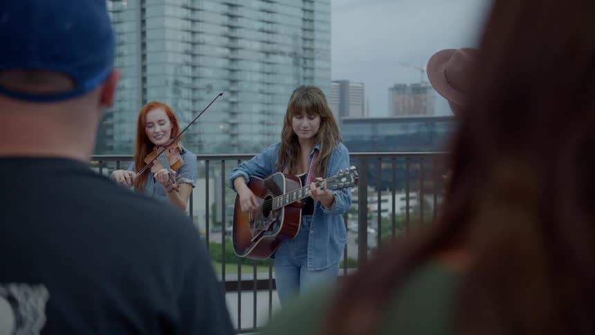 A crowd watching a group of street musicians in the evening