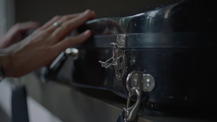 A woman opens a violin case