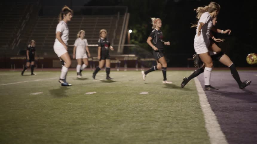 A woman soccer player makes a shot at the goal