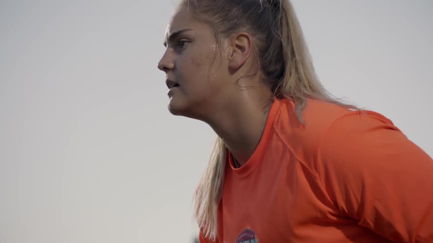 A goalkeeper barks instructions to her defense in a soccer match