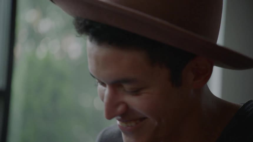 Man wearing hat laughs