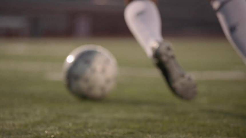 A young woman does drills with a soccer ball