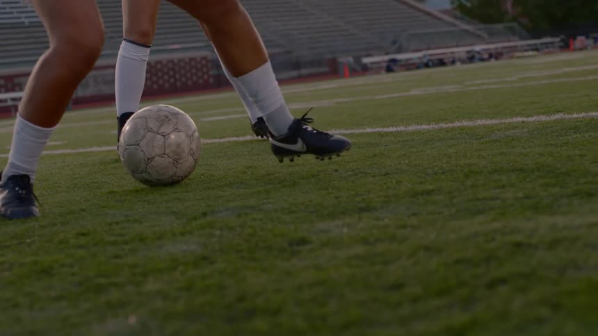 A woman dribbling with the ball in a soccer match