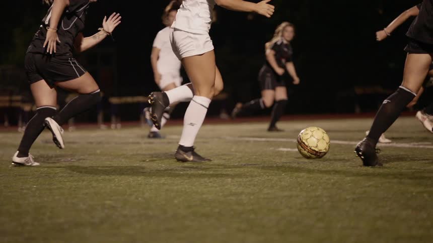 Women are competing in a professional soccer match