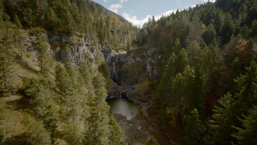 A river flows in a valley between forest covered mountains